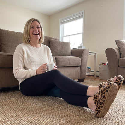 Woman relaxing on the living-room rug in Fuzzy slides in Diva Spots