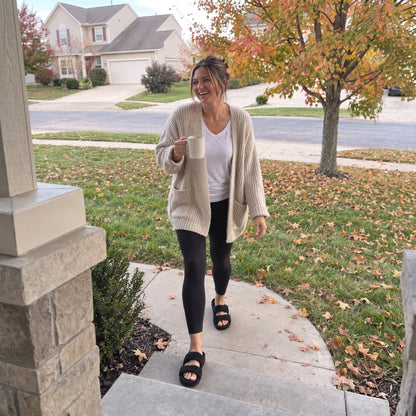 Woman walking up her front path in Fuzzy slides in Matt Black, autumn morning