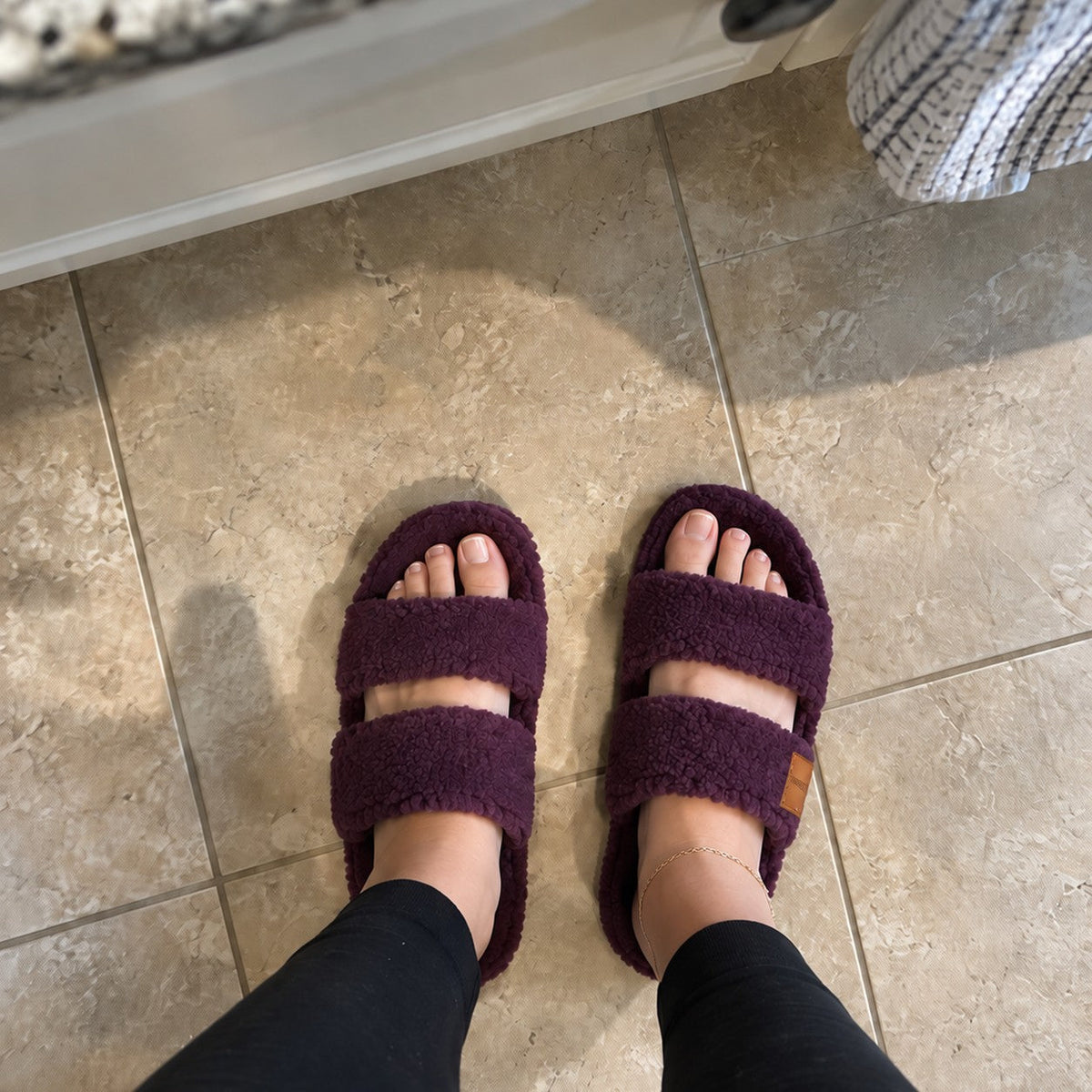 Woman wearing Fuzzy slides in Plum Violet at home
