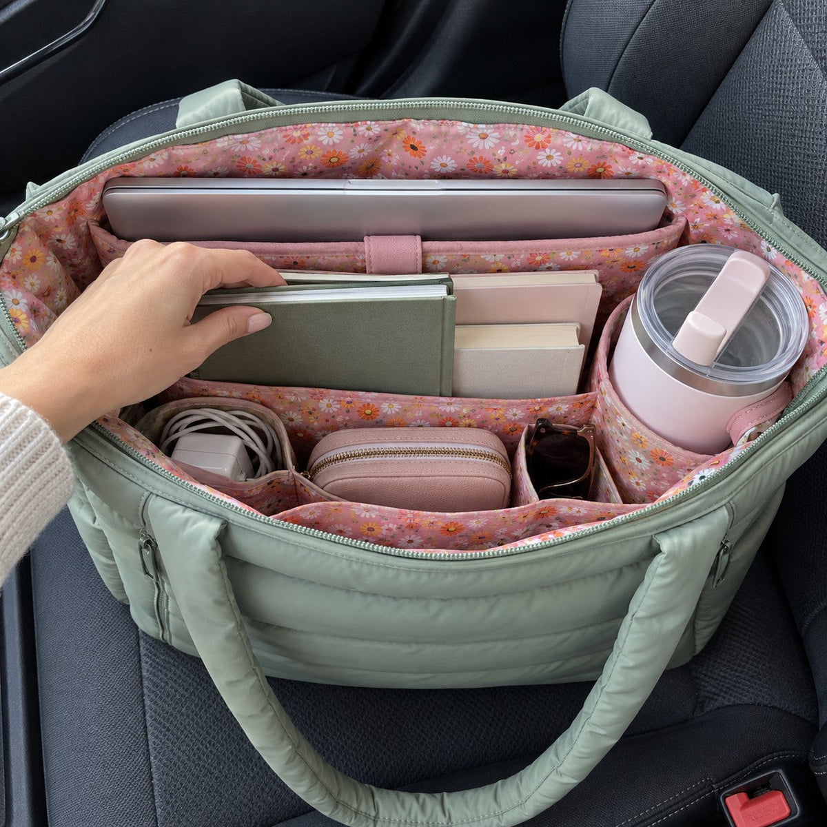 Puffy tote open from above: laptop, notebooks, tumbler and chargers organized in the pink floral lining