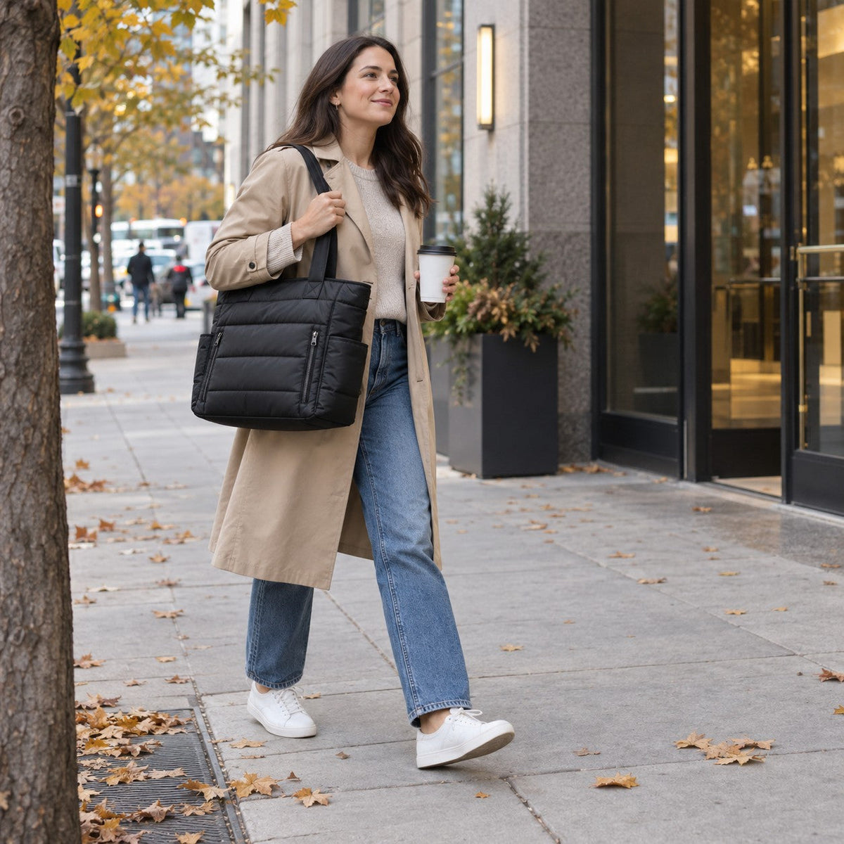 Puffy quilted puffer tote in Black, carried on the shoulder on the way to the office