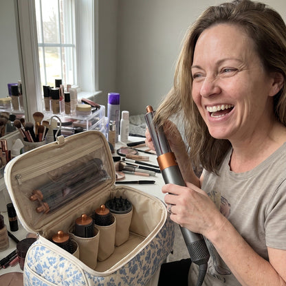 Woman styling her hair at her vanity next to the open Wrappy bag in Blue Floral